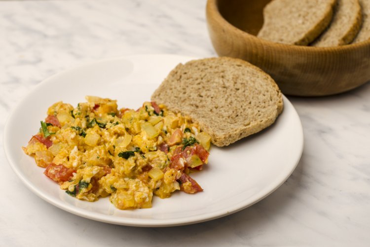 picture shows scrambled eggs and dark bread on a plate